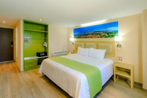 a bedroom with a large bed with a painting on the wall at Collection O Hotel Paris FC, Veracruz in Veracruz