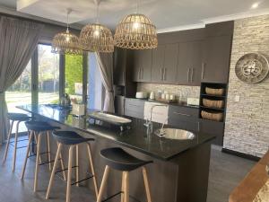 a kitchen with a large island with bar stools at Riverfront Golf Estate House in Parys