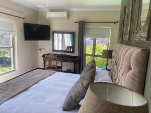 a bedroom with a bed with a couch and a television at Riverfront Golf Estate House in Parys +16 photos