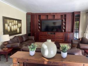 a living room with a couch and a tv at Riverfront Golf Estate House in Parys