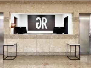 a hotel lobby with two tables and a sign on the wall at Green Rich Hotel Suizenji in Kumamoto