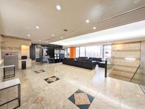 a large lobby with a couch and a table at Green Rich Hotel Suizenji in Kumamoto