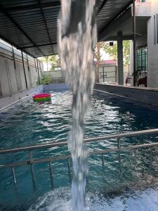 a water fountain in the middle of a swimming pool at Green Heaven Stay in Surat
