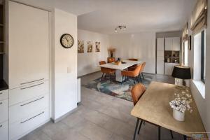 a kitchen and dining room with a table and a clock at Hidden Gem Near the Moselle River in Grevenmacher