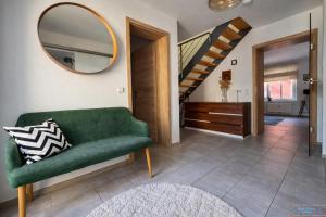 a living room with a green couch and a mirror at Hidden Gem Near the Moselle River in Grevenmacher