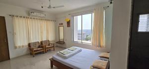 a living room with a table and a large window at Konark Villa in Mahabaleshwar +69 photos