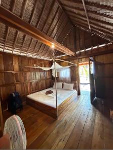 a bedroom with a bed in a wooden room at Lily's Riverhouse in Koh Rong Island