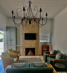 a living room with a fireplace and a chandelier at Fisherman's Rest in Paternoster