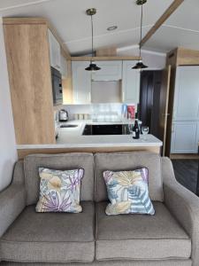 a couch with two pillows sitting in a kitchen at Pine Ridge B6 in Reighton