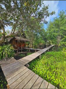 a wooden walkway in front of a house at Lily's Riverhouse in Koh Rong Island
