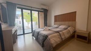 a bedroom with a bed with a stuffed animal on it at My Home Villa Phangnga in Phangnga