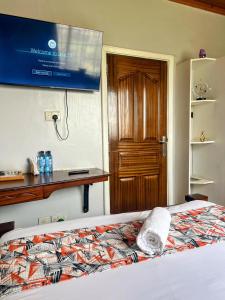 a bedroom with a bed with a tv on the wall at Westbreeze Residences in Nairobi