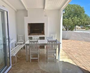 a dining room with a table and chairs and a tv at Fisherman's Rest in Paternoster