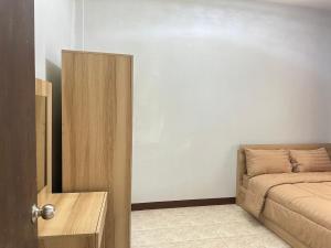a room with a bed and a door to a room with a couch at Krabicenterhome in Ban Tha Nun