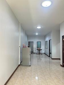 an empty room with a refrigerator and a table at Krabicenterhome in Ban Tha Nun