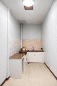 a kitchen with white cabinets and a sink at Krabicenterhome in Ban Tha Nun