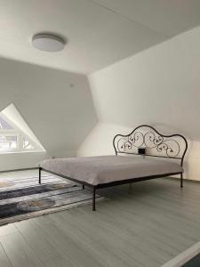 a bed in a white room with a bed frame at „Sėlių Studio“ Apartamentai in Utena