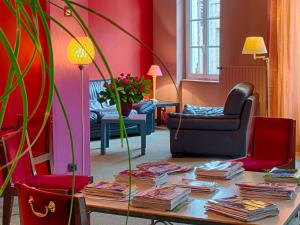 een woonkamer met een tafel met boeken erop bij Hotel de Bordeaux in Pons