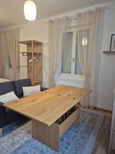 a wooden table in a living room with a couch at le st fursy 1 in Péronne