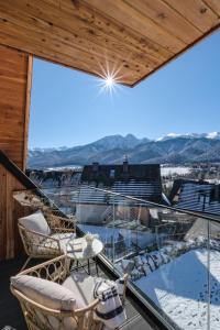 a balcony with chairs and a view of the mountains at Apartamenty 3 Owce z widokiem na Giewont in Kościelisko +78 photos