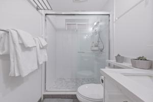 a white bathroom with a shower and a toilet at Central Van 1bedroom Suite in Vancouver +13 photos