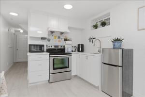 a white kitchen with white cabinets and appliances at Central Van 1bedroom Suite in Vancouver