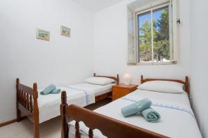 two twin beds in a room with a window at Stone House Villa Darinka in Vela Luka +49 photos