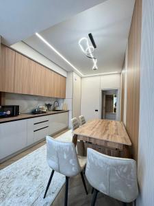 a kitchen with a wooden table and chairs at Eleon apartment in Bishkek