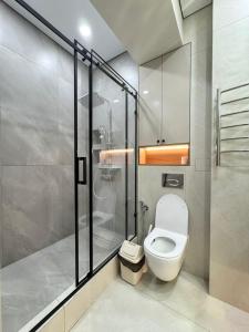 a bathroom with a toilet and a glass shower at Eleon apartment in Bishkek