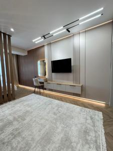 a living room with a flat screen tv on a wall at Eleon apartment in Bishkek
