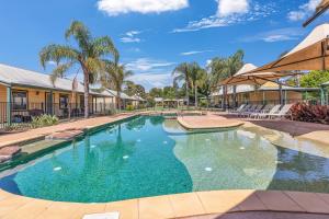 a swimming pool with blue water in a resort at Murray River Resort in Moama