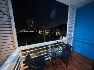a table and chairs on a balcony at night at Blue Apartment in Pattaya