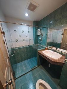 a bathroom with a shower and a sink and a toilet at Blue Apartment in Pattaya