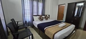 a small bedroom with a bed and a chair at Brighton Stays in Sultan Bathery