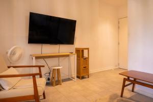 a living room with a flat screen tv on a wall at ELYMUS - Spacious 3-Bedroom Apartment With Private Rooftop and Balcony - Near Le Morne And Lagoon in La Gaulette +20 photos