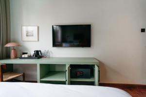 a green desk with a tv on a wall at Céline & Lolo in Nairobi
