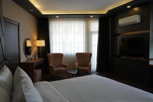 ein Hotelzimmer mit einem Bett und zwei Stühlen in der Unterkunft Sultasa Hotel in Mersin + 30 Fotos
