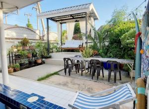 a patio with a table and chairs next to a pool at Baan Khun Pim Pool Villa in Ban Suan Maphrao