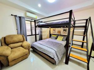 a bedroom with a bunk bed and a chair at Baan Khun Pim Pool Villa in Ban Suan Maphrao +15 photos
