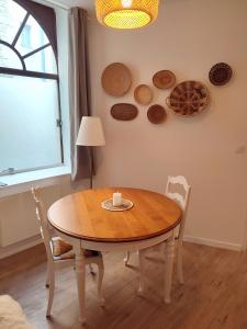 a dining room table with a candle and plates on the wall at Le Bohème in Chaumont