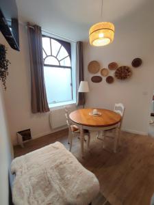 a dining room with a table and chairs and a window at Le Bohème in Chaumont