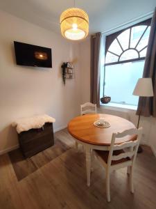 a dining room with a table and chairs and a window at Le Bohème in Chaumont