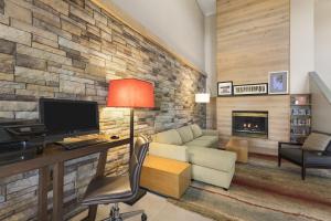 a living room with a computer desk and a fireplace at Country Inn & Suites by Radisson, Ankeny, IA in Ankeny