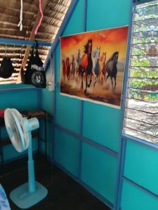 a blue room with a painting of horses on the wall at rut66 in Ko Phayam