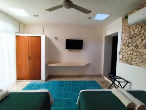 a bedroom with two beds and a flat screen tv at Casa colonial tranquila cerca del centro, Casa Solecito in Valladolid