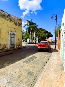 a red car parked on the side of a street at Casa colonial tranquila cerca del centro, Casa Solecito in Valladolid