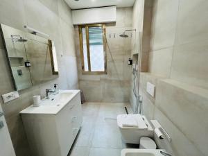 a white bathroom with a sink and a toilet at Terme Boutique House in Montegrotto Terme +15 photos