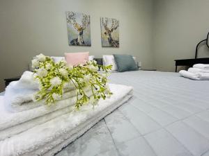 a bedroom with a large white bed with flowers on it at Terme Boutique House in Montegrotto Terme