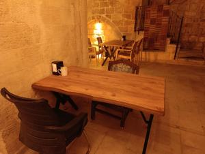 a wooden table in a room with tables and chairs at Babussor konağı hotel in Eskiömerler