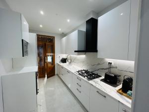 a white kitchen with a stove and white cabinets at Terme Boutique House in Montegrotto Terme